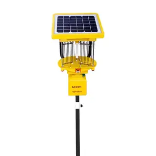 Solar black-light insect lamp on a pole in an orchard